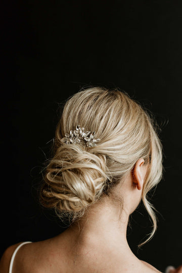 Low bun wedding hairstyle with simple crystal hair comb